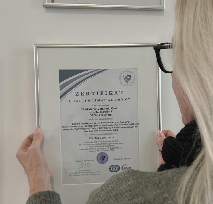Frau schaut auf die Urkunde der Zertifizierung.